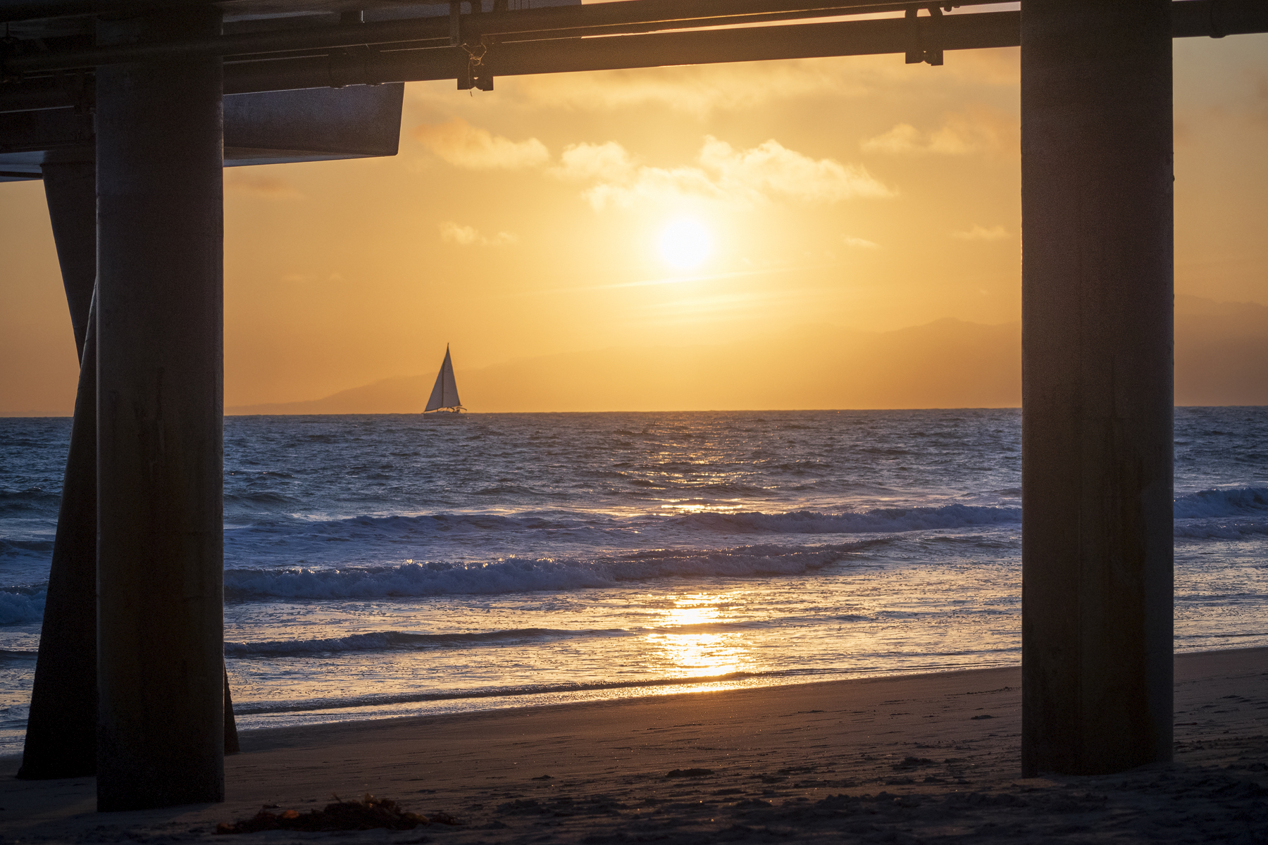 Lonely boat begins a voyage into the sunset at Venice Beach, California