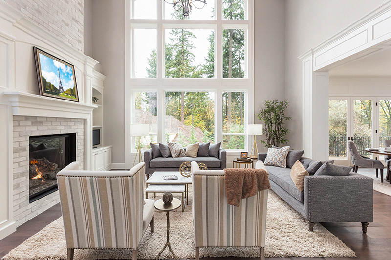 Fine Art Displayed in living room interior with hardwood floors and fireplace in new luxury home.