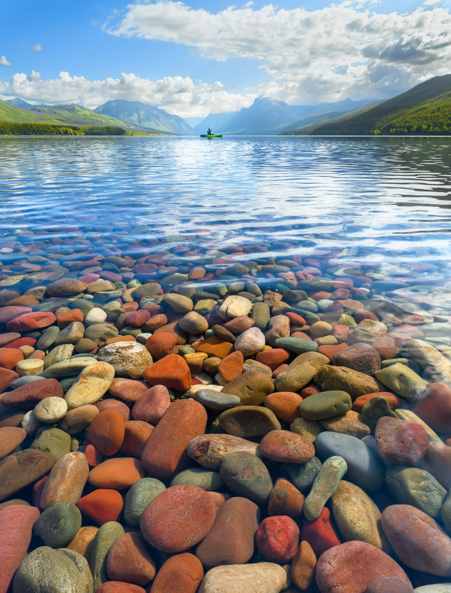 Kayak floats above the colorful rocks of Lake McDonald in Glacier National Park.